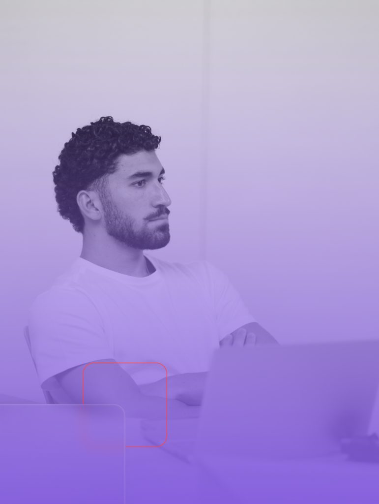 Homem jovem de cabelos cacheados e barba, vestindo uma camiseta branca, sentado com os braços cruzados e olhando atentamente para frente. Ele está em um ambiente minimalista e iluminado, com um laptop à sua frente. A imagem tem um filtro em tons de roxo e lilás, com elementos gráficos modernos, como formas geométricas translúcidas e linhas vermelhas sutis, criando um efeito tecnológico e contemporâneo.